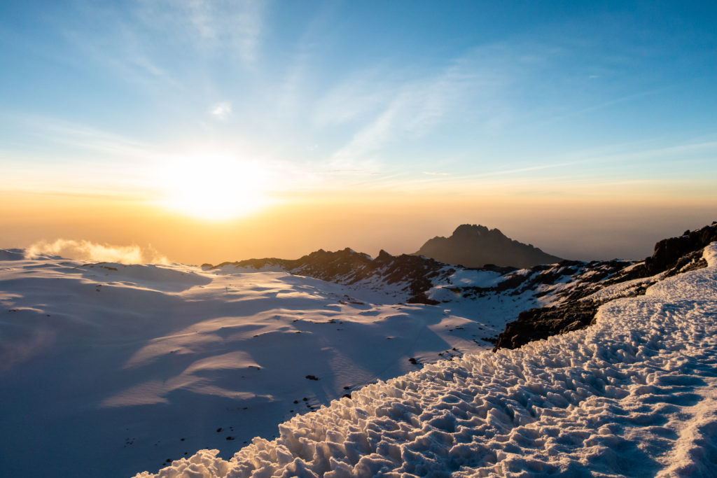 Sonnenaufgang am Kraterrand des Kilimanjaros mit Schnee