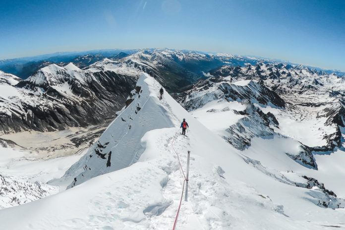 Bergsteiger am verschneiten Gipfelgrat des Großglockner