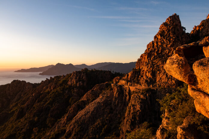 Die letzten Sonnenstrahlen treffen auf die Felsen der Calanche