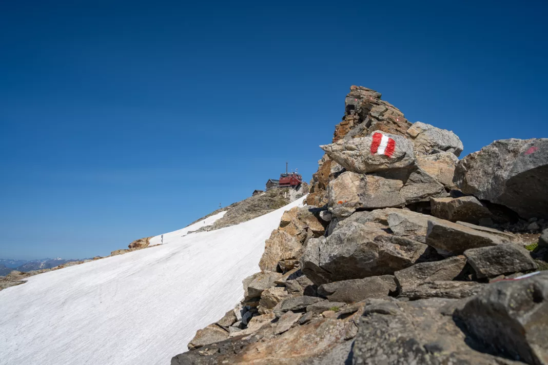 Am Gipfelgrat des Hohen Sonnblicks mit dem Zittelhaus im Hintergrund