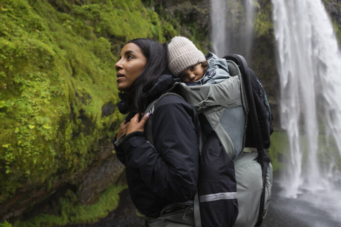 Wanderer mit Baby in einer Kraxe in Island