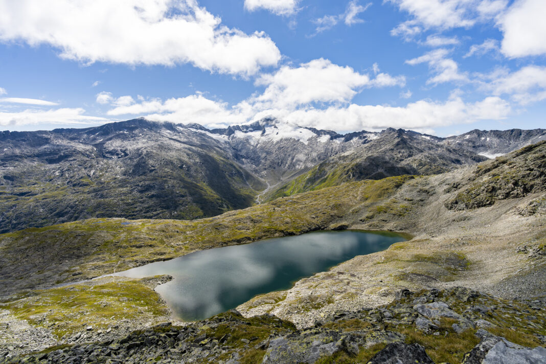 Blick hinunter zum Unteren Schwarzhornsee; dahinter schlüpft die Tauernkönigin langsam aus ihrer Wolkendecke