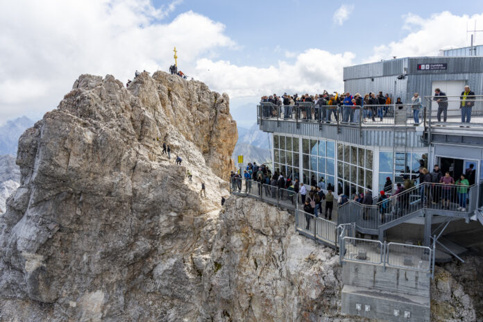 Viele Bahngäste wollen ebenfalls ein Foto mit dem Gipfelkreuz, das sorgt für Stau