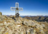 Das Gipfelkreuz des Pletzen, im Hintergrund die Gesäuse-Berge